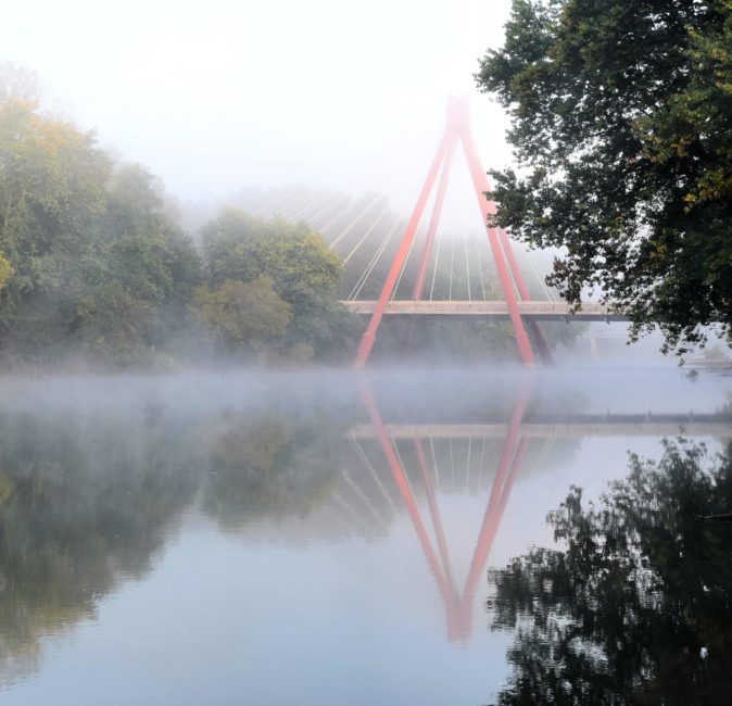 river with red bridge with fog by Ginger Jordan