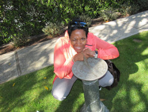 Cherrie Davis posing with a sundial